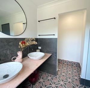 La salle de bains est pourvue de 2 lavabos et d'un miroir. dans l'établissement Relaxing Burleigh Heads Home with Swimming Pool, à Gold Coast