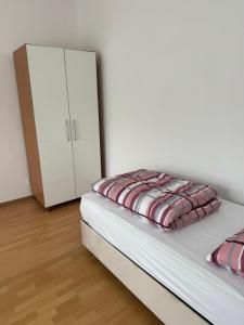 um quarto com uma cama e um armário branco em Pension - Panorama em Gundelsheim