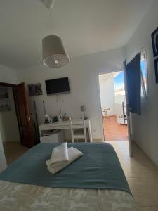 a bedroom with a bed with a television and a desk at MiVida in San Bartolomé