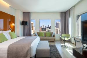 Habitación de hotel con cama grande y ventana grande. en Crowne Plaza Tel Aviv City Center, an IHG Hotel en Tel Aviv