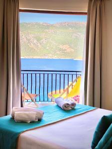a bed in a room with a large window at Club Hotel Barbarossa in Kaş
