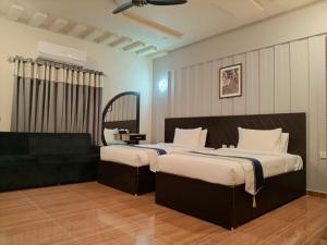 Un pat sau paturi într-o cameră la MZ Hotel and Restaurant Sukkur