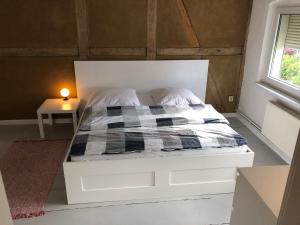 a white bed in a room with a window at Charmantes Haus direkt am Oder-Nationalpark in Lunow