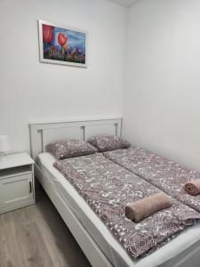a bed in a bedroom with a picture on the wall at Éva Apartmanház in Csopak