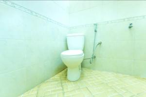 a bathroom with a white toilet in a room at Senaz Guesthouse in Mataram