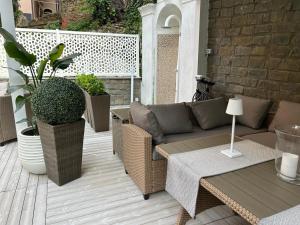 a patio with a couch and tables and plants at FIESCHI Rooms in Genoa