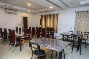 OYO NIMALAN RESIDENCY في تشيناي: غرفة طعام فيها طاولات وكراسي