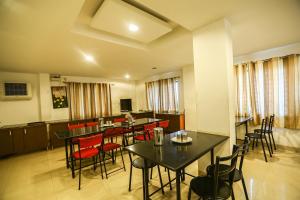 - une salle à manger avec des tables, des chaises et des fenêtres dans l'établissement OYO NIMALAN RESIDENCY, à Chennai