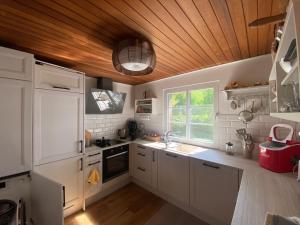a kitchen with white cabinets and a wooden ceiling at Ferienwohnung Hohenheide in Warendorf