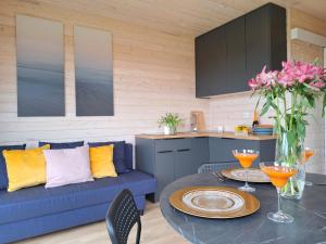 a living room with a blue couch and a table at Domki Letniskowe Rewa in Rewa