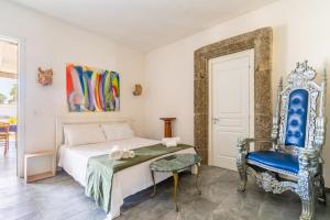 a bedroom with a bed and a blue chair at Masseria Le Dimore in Gallipoli