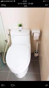 a bathroom with a toilet with a plant on top of it at Veganhome in Ho Chi Minh City