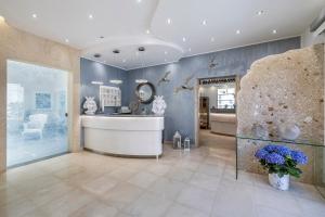 un ampio bagno con lavandino e specchio di Hotel Soffio D'Estate a San Vito lo Capo