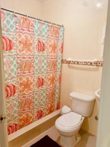 a bathroom with a toilet and a shower curtain at Hotel Vista Sur in Los Patos