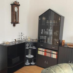 a black cabinet with a sink and a clock at Zimmervermietung im Eigenheim in Göda