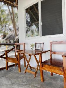 stół i dwa krzesła oraz stół i stół w obiekcie Zanzibar Gem Beach Bungalows w mieście Bwejuu