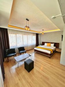 a bedroom with a bed and a table and chairs at Pera Pansiyon in Bursa