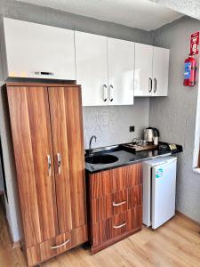 a kitchen with wooden cabinets and a white refrigerator at Pera Pansiyon in Bursa