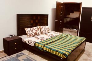 sypialnia z łóżkiem z drewnianym zagłówkiem w obiekcie Islamabad Holiday Appartments One & Two Bed A Perfect Winter Escape to Murree, Northern Areas & Beyond w mieście Islamabad