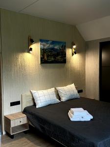 ein Schlafzimmer mit einem Bett und einem Wandgemälde in der Unterkunft Садиба Деревій in Izky