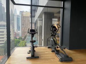 un gimnasio con 2 bicicletas estáticas frente a una ventana en Anggun Suite KL en Kuala Lumpur
