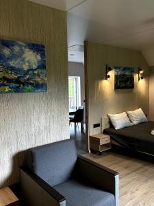 ein Schlafzimmer mit einem Bett und einem Stuhl in einem Zimmer in der Unterkunft Садиба Деревій in Izky