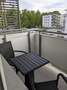 a balcony with a table and a bench on a roof at Apartment Olympia in Wrocław