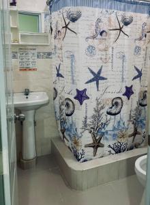 a bathroom with a shower curtain and a sink at Hotel Vista Sur in Los Patos