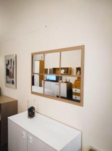 een spiegel aan een muur boven een witte tafel bij LF_SUITE_ Lugano Lake_ Ampia Terrazza ; Spiaggia privata_ WI-FI_ Netflix_ in Porlezza