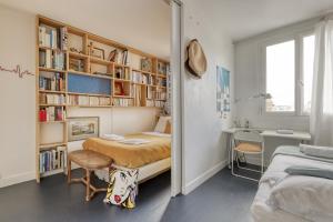 ein Schlafzimmer mit einem Bett, einem Schreibtisch und einem Bücherregal in der Unterkunft Stunning Flat with Balcony - Boulogne / Paris 16 in Boulogne-Billancourt