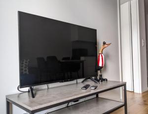 een grote flatscreen-tv zittend op een tafel bij Apartment Olympia in Wrocław