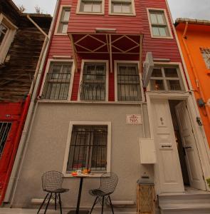une maison rouge avec deux chaises et une table devant elle dans l'établissement NİA SULTANAHMET, à Istanbul