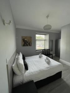a bedroom with a bed with white sheets and pillows at Lundy House Hotel in Woolacombe