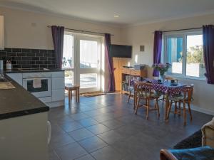 a kitchen and dining room with a table and chairs at Llainfawr Cottage Apartment Fishguard in Letterston