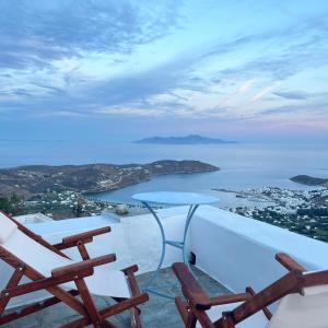 un balcón con 2 sillas, una mesa y el océano en Castle seaview retreat en Alona