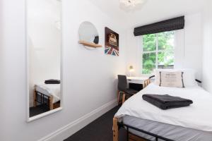 a bedroom with two beds and a mirror at Trendy Terraced House in Central Oxford in Oxford