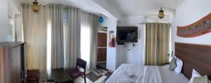 a bedroom with a bed and a tv in a room at Peacock Guest House - Lake View Hotel In Udaipur in Udaipur