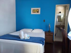 a blue room with a bed with towels on it at Pousada Ouro Preto in Ouro Preto