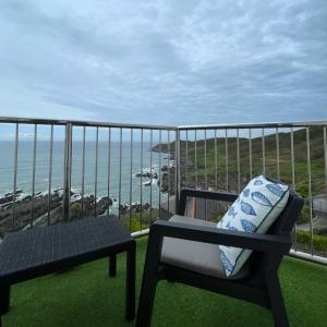a chair on a balcony with a view of the ocean at Lundy House Hotel in Woolacombe