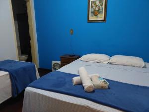 two beds in a room with blue walls at Pousada Ouro Preto in Ouro Preto