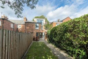 a brick house with a fence and a yard at Trendy Terraced House in Central Oxford in Oxford