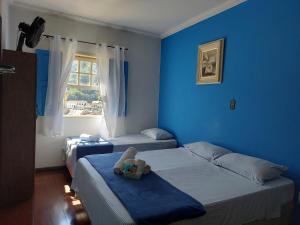 um quarto azul com duas camas e uma janela em Pousada Ouro Preto em Ouro Preto