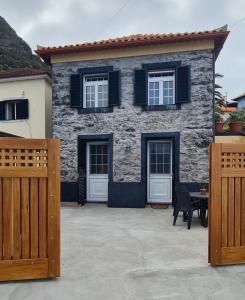 a house with two doors and a table in front of it at Casa do Amigo in Seixal