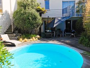 a swimming pool in front of a house at L Oliveraie - Piscine chauffee in Les Sables-dʼOlonne