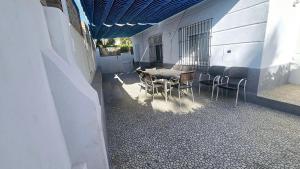 eine Terrasse mit einem Tisch und Stühlen neben einem Gebäude in der Unterkunft Bungalow Andalucia in Rincón de la Victoria