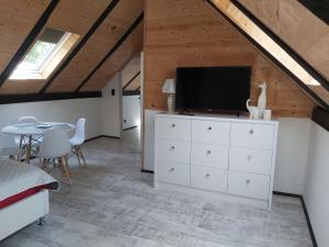 a living room with a tv on a dresser and a table at Domek u Szajnosi in Bogusławiec