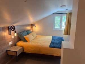 a bedroom with a bed with a wooden headboard and a window at Gîte Les Lilas, centre Alsace, avec jacuzzi in Mackenheim +34 photos