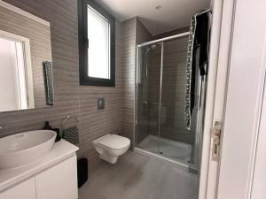La salle de bains est pourvue de toilettes, d'un lavabo et d'une douche. dans l'établissement Cozy 3 Bedroom Apartment 300M from the SEA, à Larnaka