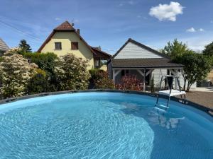 a swimming pool in front of a house at Gîte Les Lilas, centre Alsace, avec jacuzzi in Mackenheim