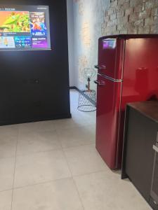 a red refrigerator in a room with a tv at A charming loft in the heart of KRAKÓW with free parking in Krakow